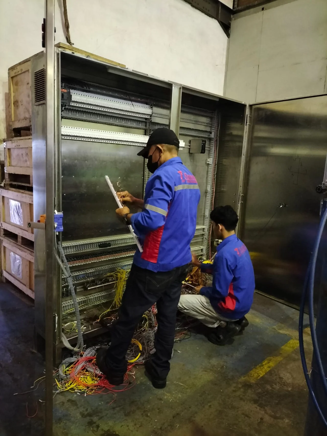 Technicians working beside industrial equipment